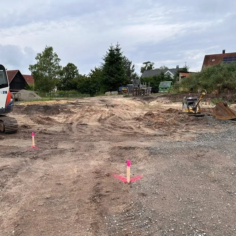 Abgesteckte Gebäudeecken mit Pflöcken auf einem Baugrundstück